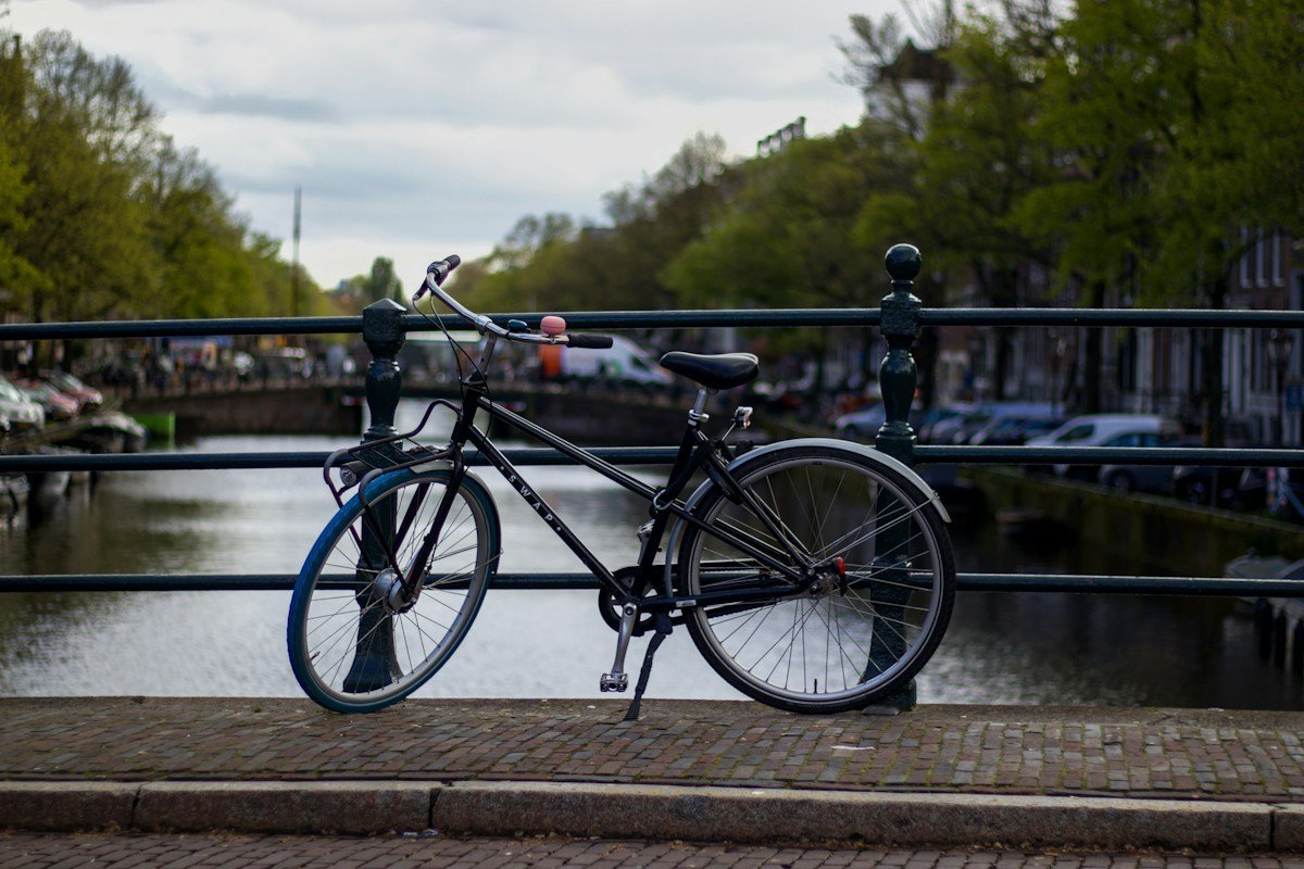 Ein Fahrrad lehnt an einem Brückengeländer über einem Kanal