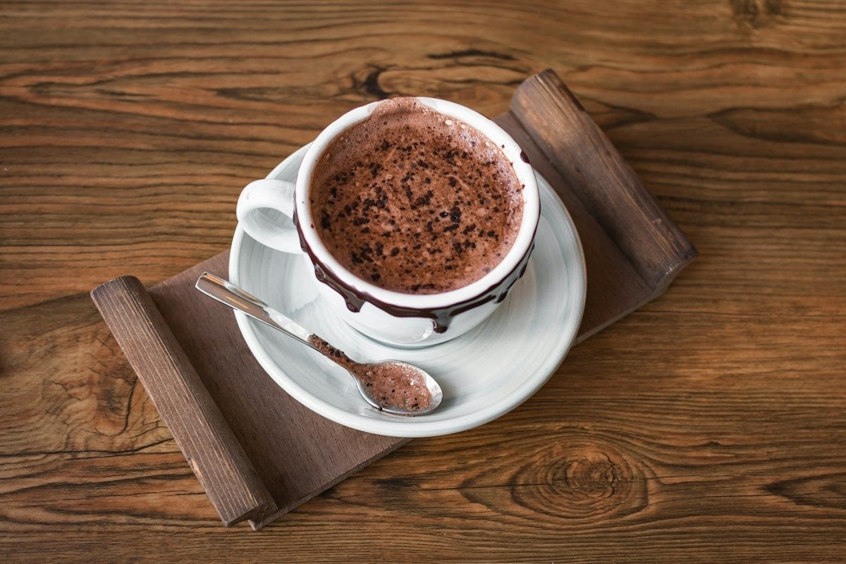 Eine Tasse Kakao auf einem Holzbrett