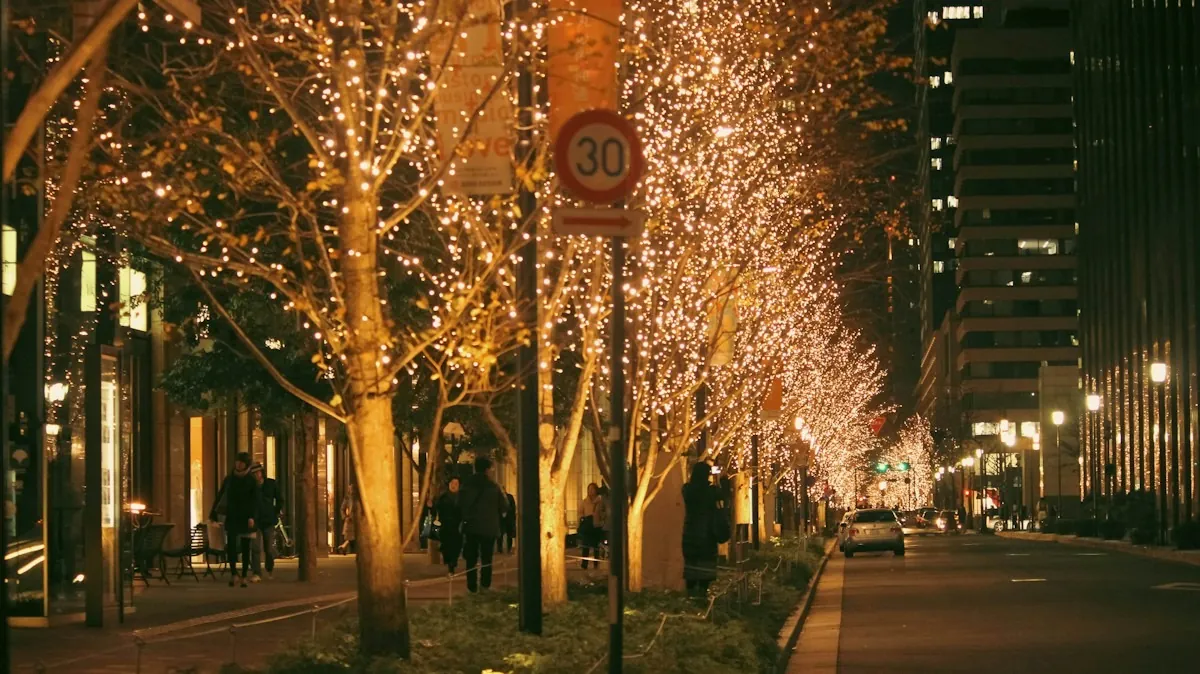 Bäume mit Lichterketten säumen einen Weg in der Stadt am Abend
